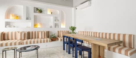 A modern living room with a wooden dining table, striped sofas, and a coffee table.
