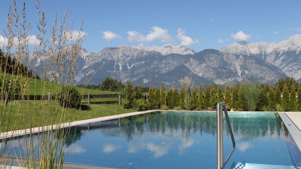 A swimming pool with a mountain backdrop. - Hotel Geisler Tulfes (Tulfes)