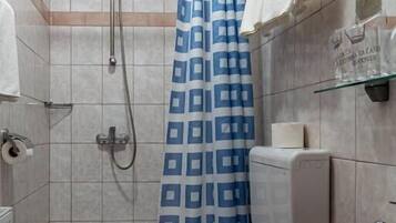 Een badkamer met een douche, toilet en wastafel.