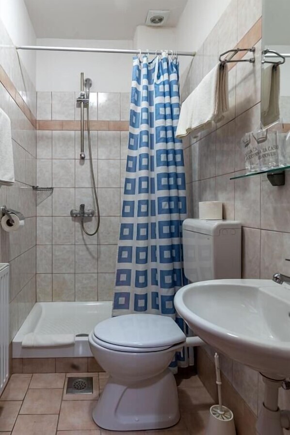 A bathroom with a shower, toilet, and sink. - Hotel Porto (Zadar)