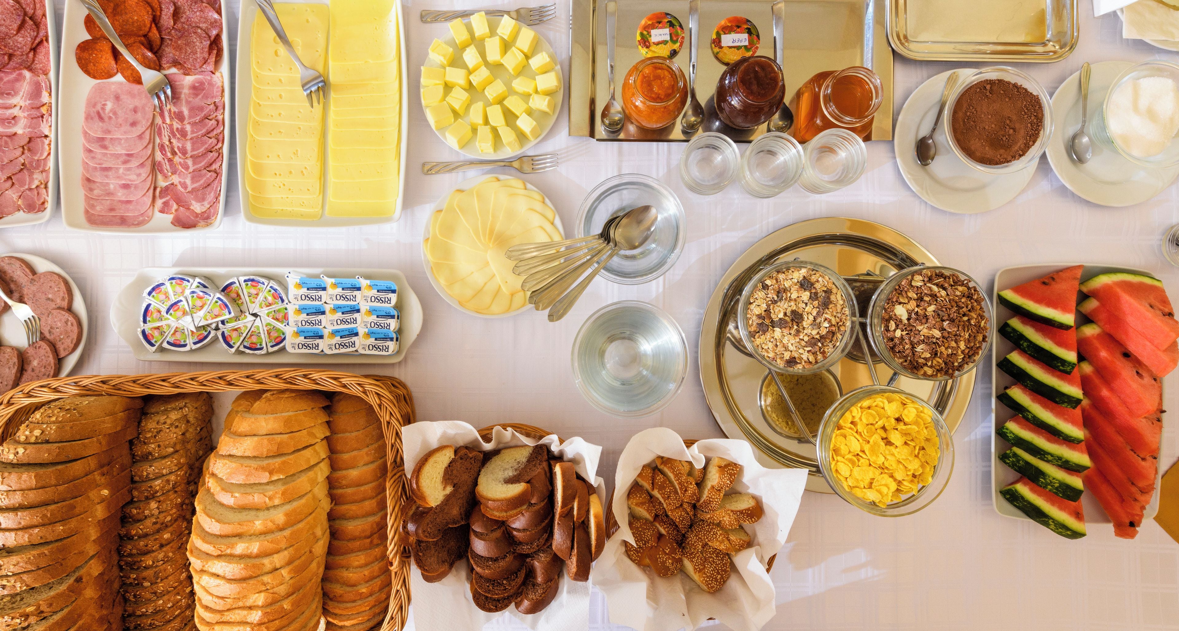 Une variété d’aliments, notamment des viandes tranchées, des fromages et des fruits, disposés sur une table.