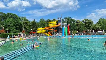 A swimming pool with multiple lanes and a water slide structure.