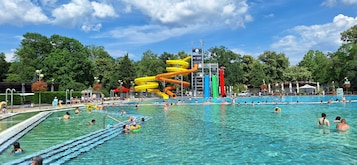 A swimming pool with multiple lanes and a water slide structure.