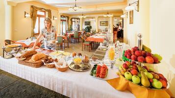 Un bufé de desayuno con diversas opciones de comida y una exhibición de frutas.