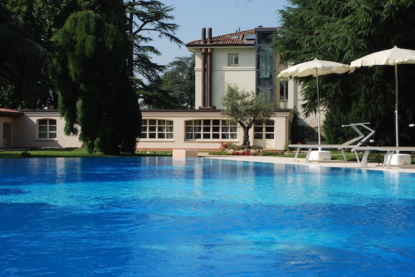 Una piscina al aire libre de temporada, sombrillas