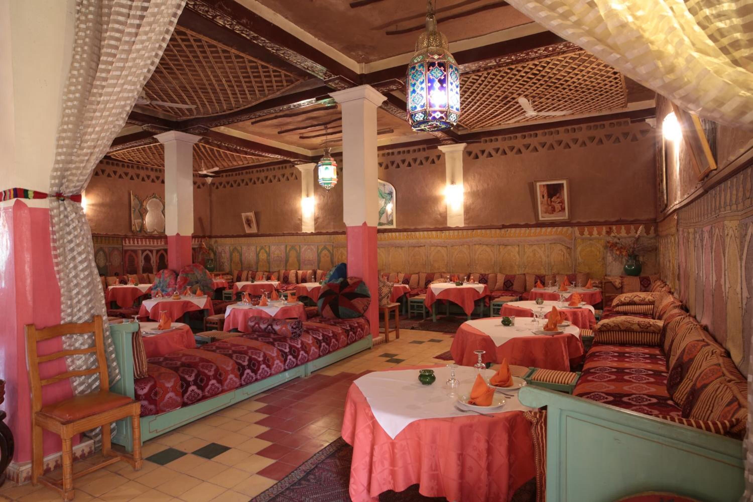 Ein traditionelles Restaurant mit mehreren Essbereichen, jeweils mit Tischen und Stühlen.