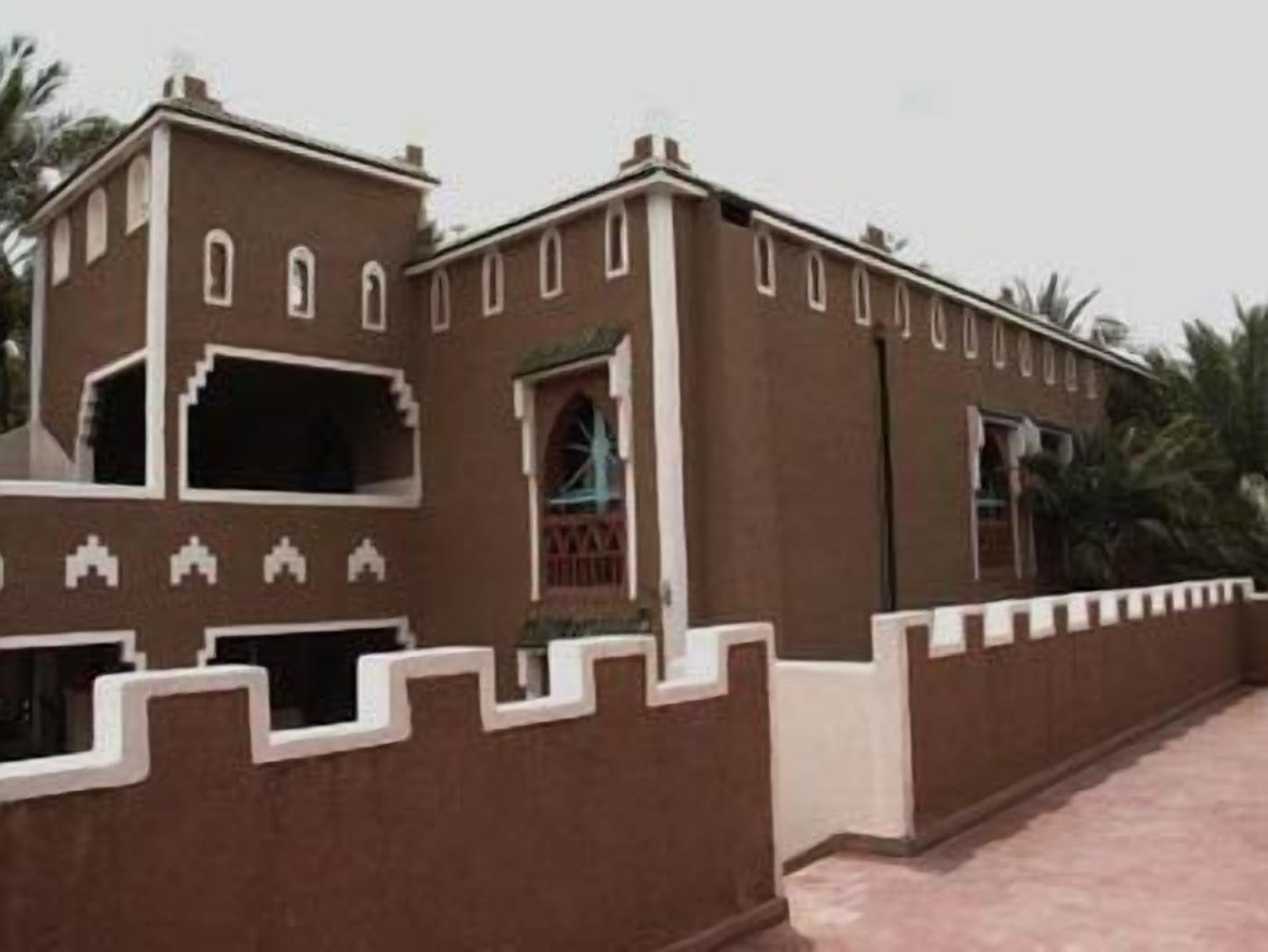 A traditional building with a symmetrical facade, featuring arched windows and decorative white trim.