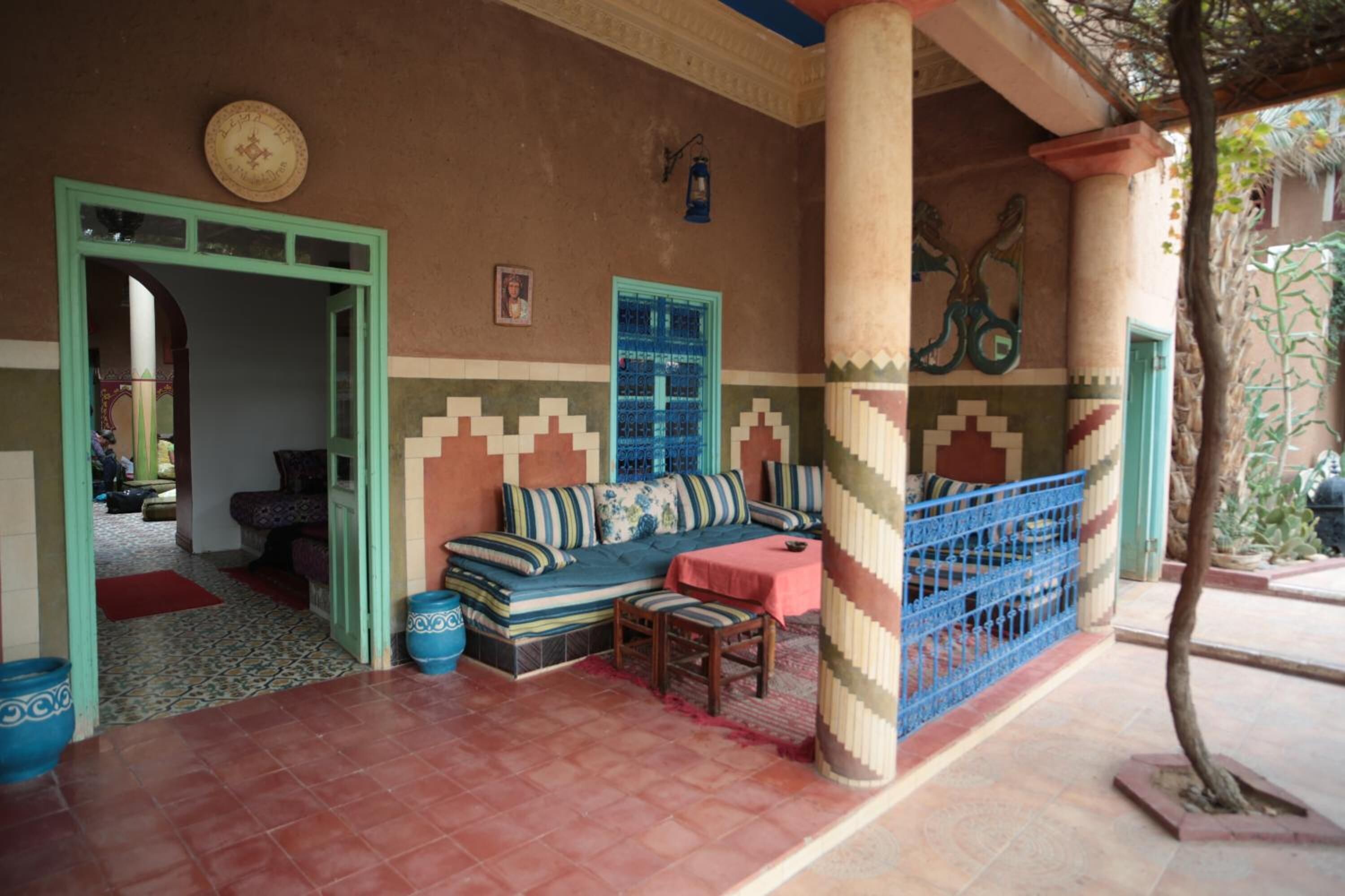 Un espace extérieur aménagé, abrité et doté d’un canapé et de fauteuils, d’un mur décoratif et d’une petite table.