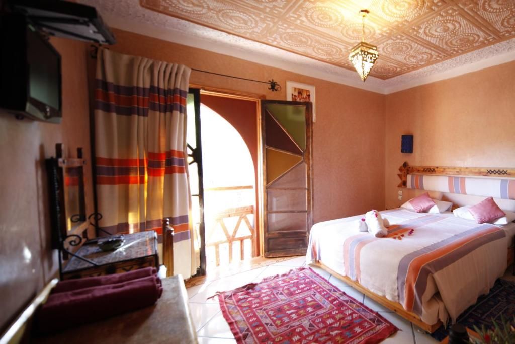 Un dormitorio con cama, cortinas, un tapete estampado y un techo con diseños elaborados.