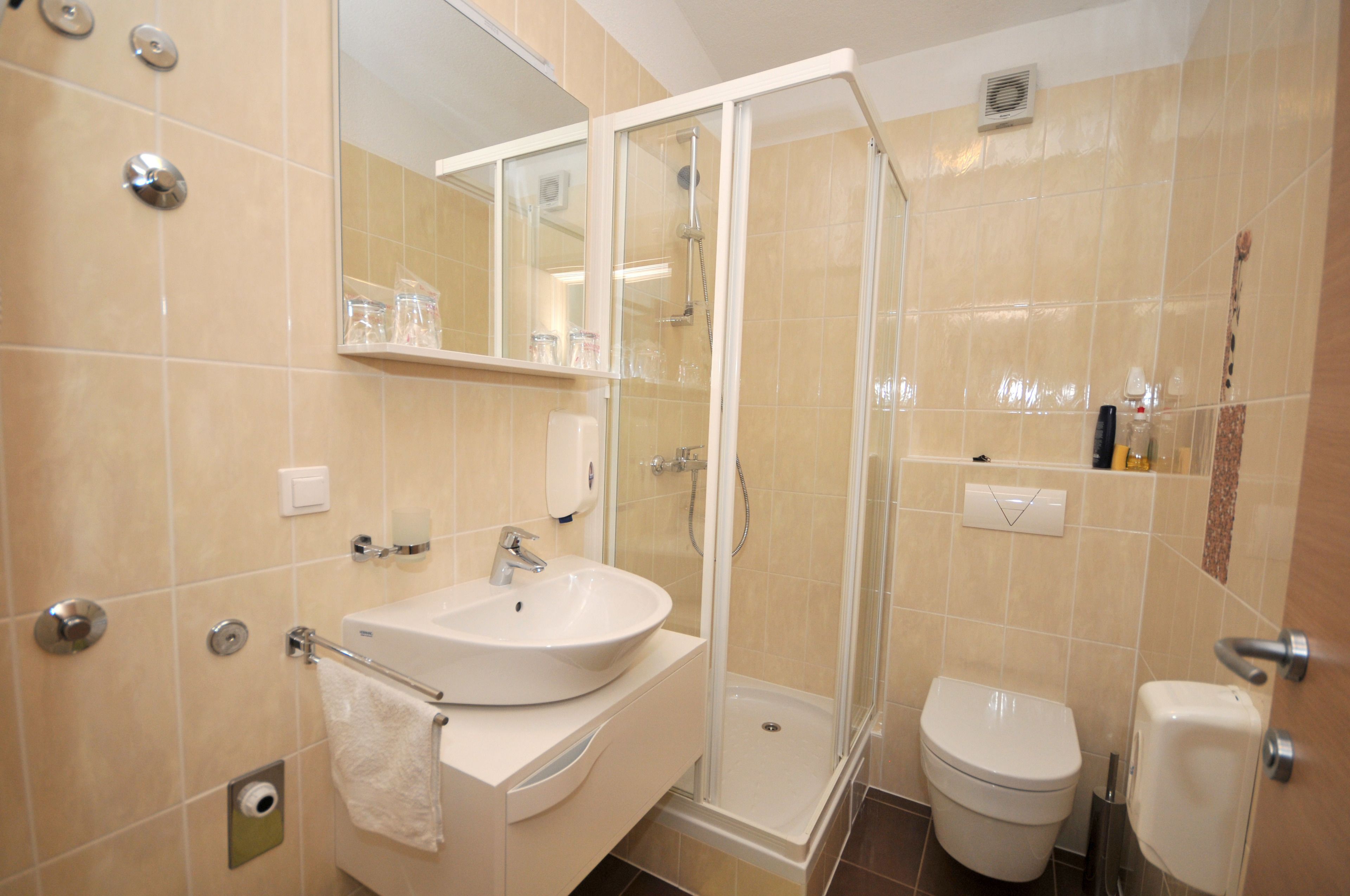 Un baño moderno con lavamanos, inodoro y ducha envuelta en vidrio.