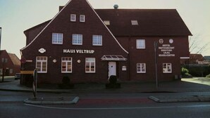 A two-story brick building with a sign reading "HAUS VELTRUP HOTEL RESTAURANT." - Hotel Veltrup (Laer)