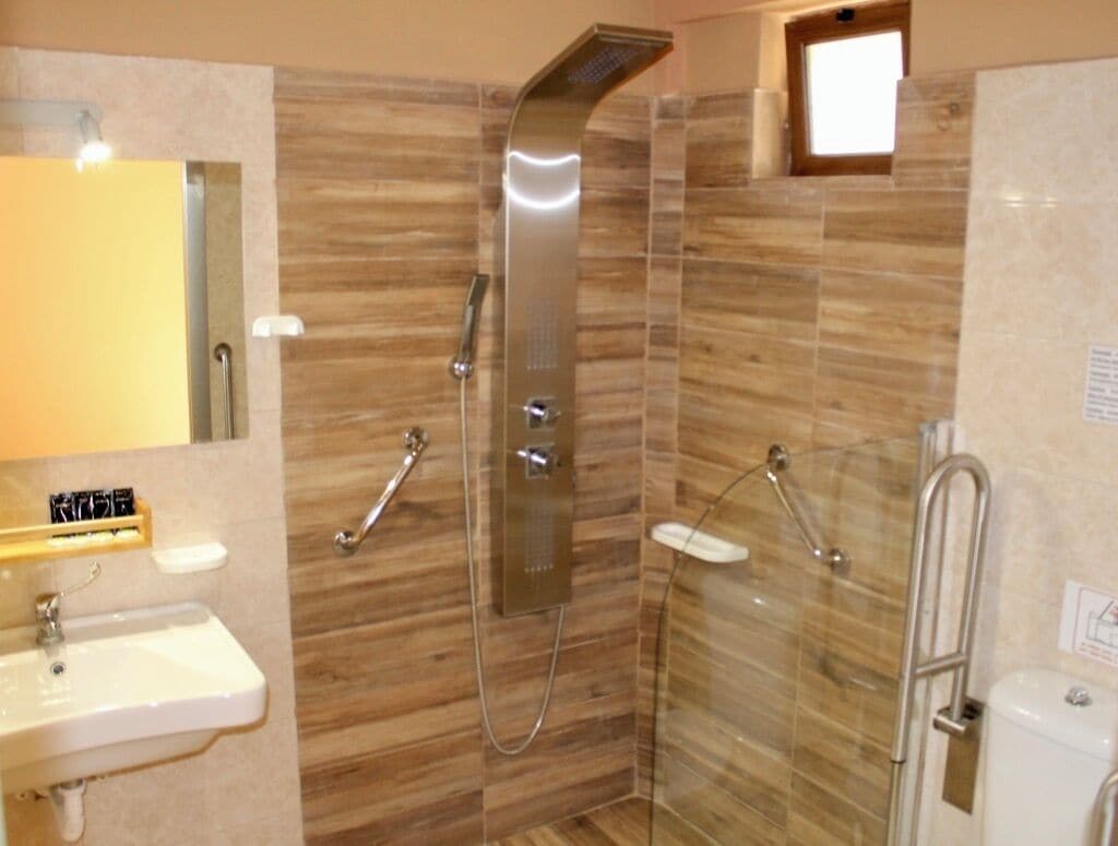 A bathroom with a shower, sink, and toilet.