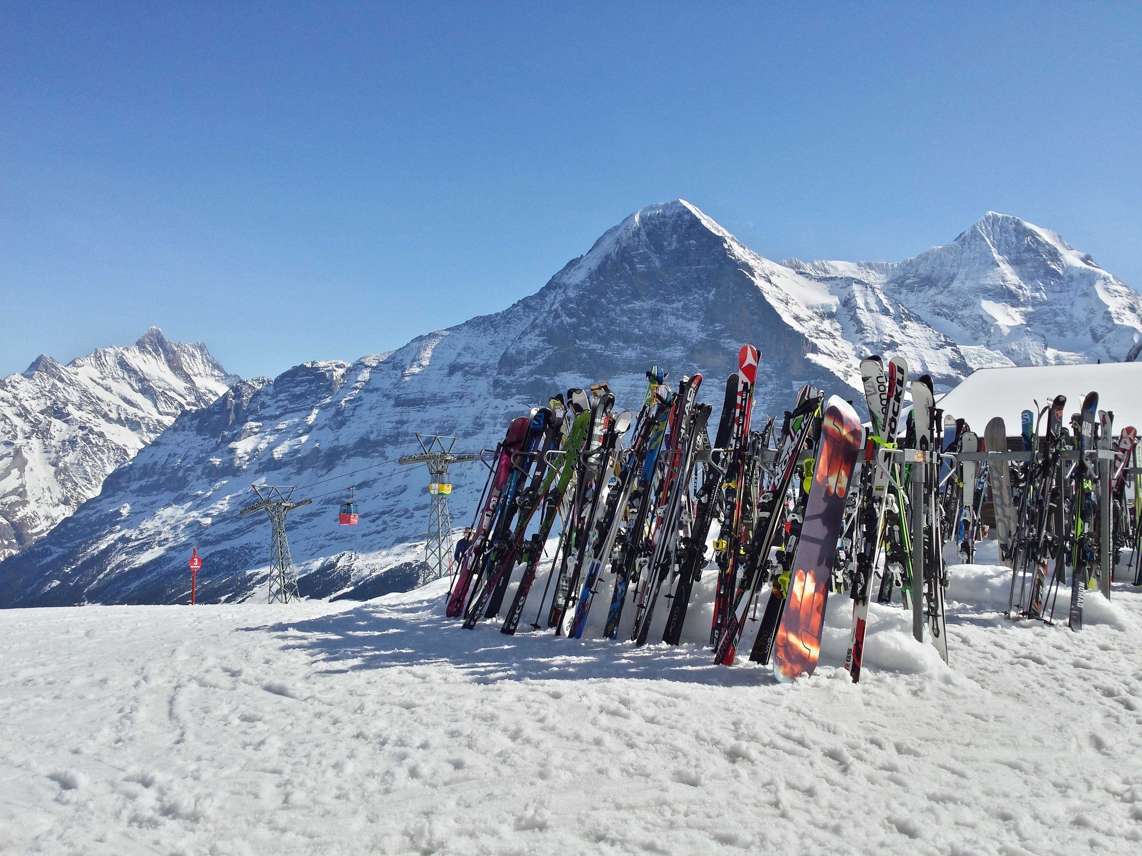 Une piste de ski avec une rangée de paires de skis et un télésiège en arrière-plan.