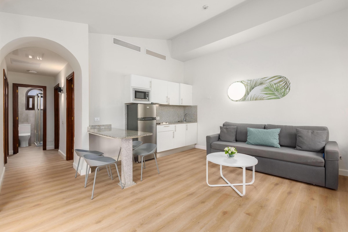 A modern apartment with a kitchen, dining area, and living room.
