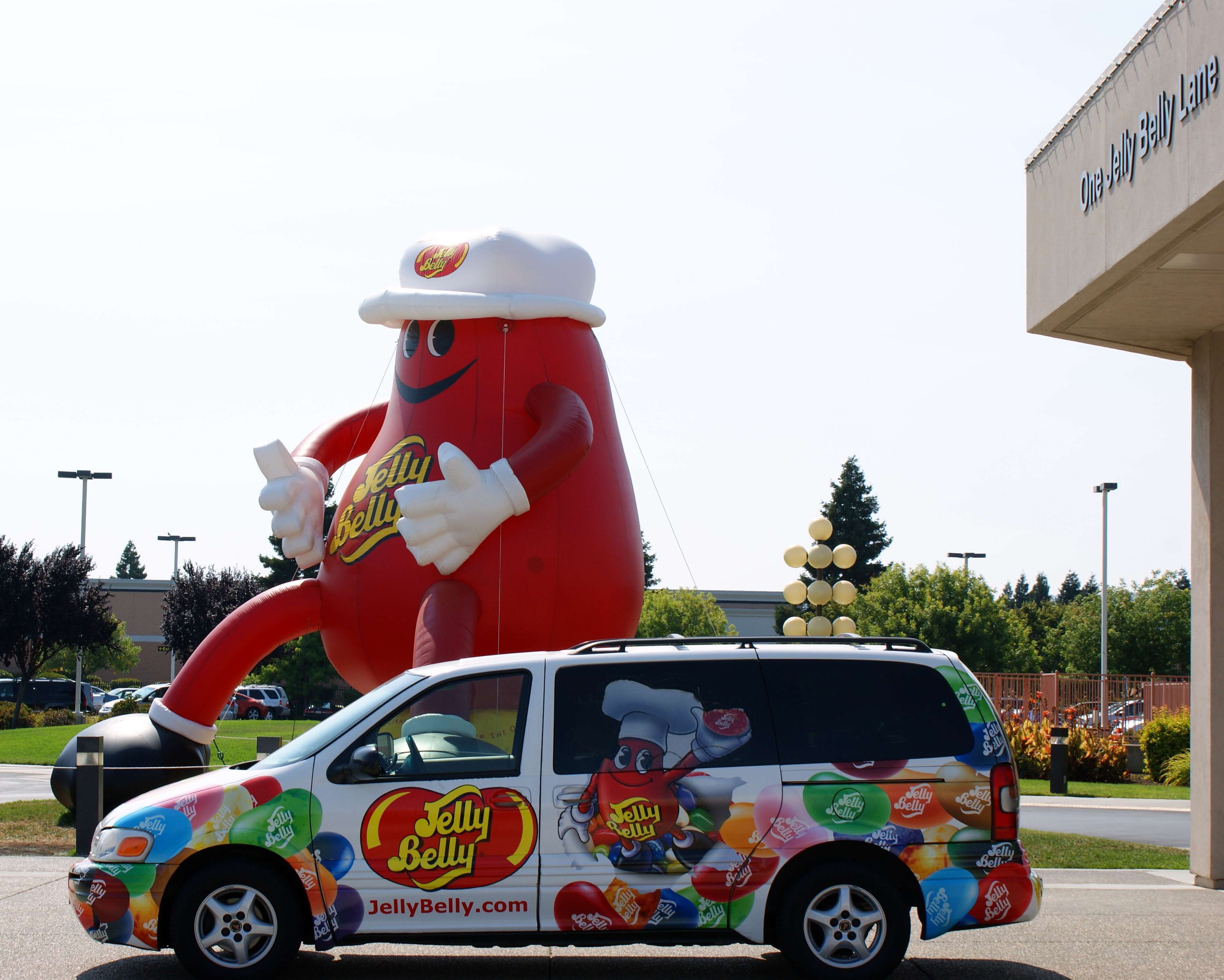 Un véhicule arborant les couleurs de la marque Jelly Belly et surmonté d’une grande figurine représentant la mascotte.