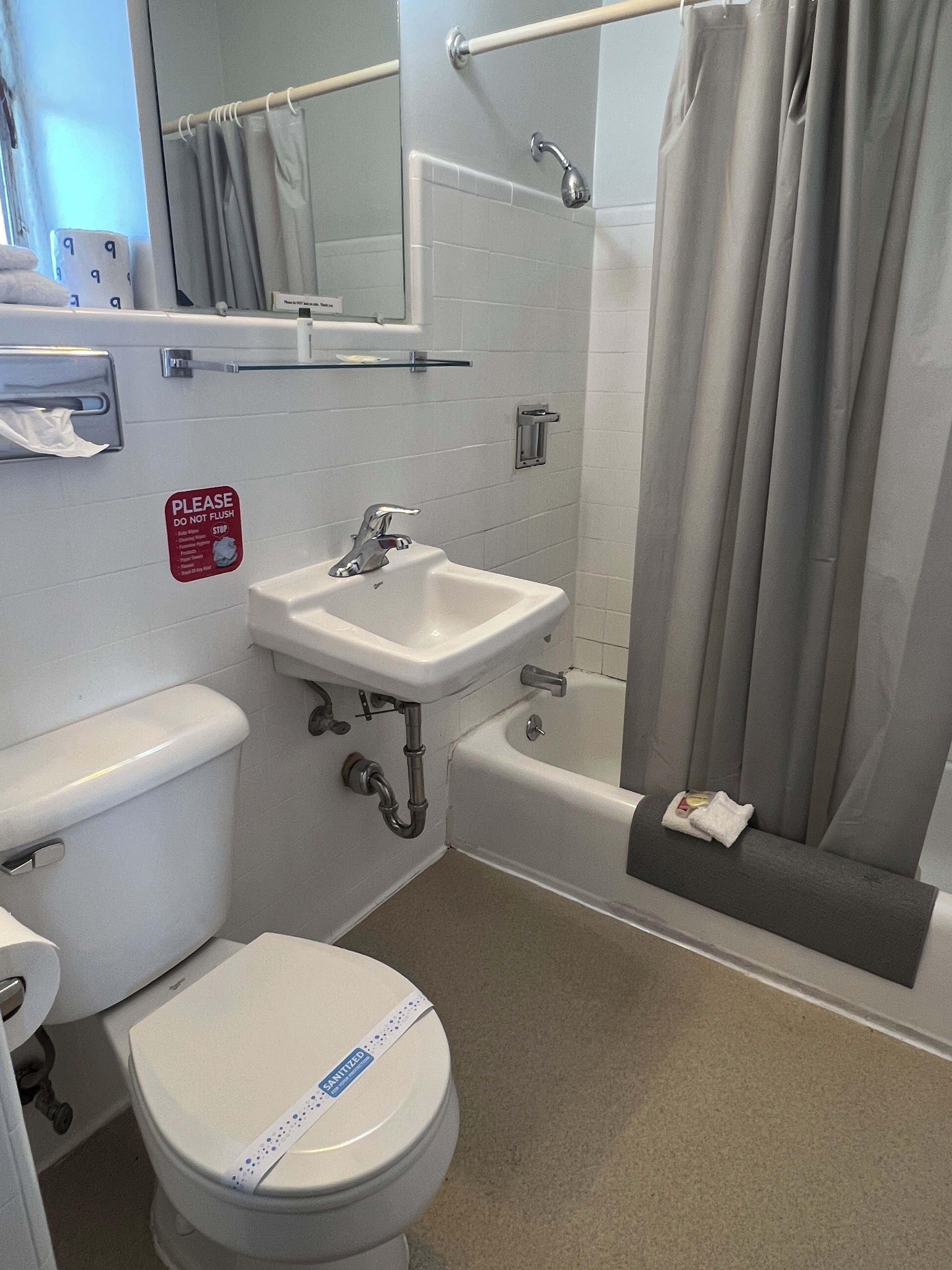 A bathroom with a toilet, sink, and bathtub.