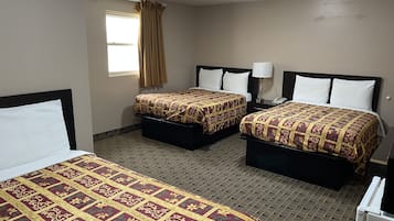 Une chambre d’hôtel avec deux lits, une fenêtre avec des rideaux, une lampe de chevet et un radiateur.