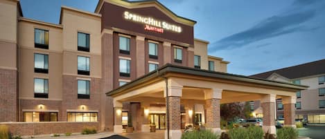 A SpringHill Suites Marriott hotel with a covered entrance, brick facade, and multiple windows.