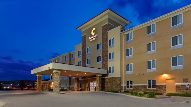 Ein Hotel mit einem zentralen Eingang, mehreren Stockwerken und einem Schild für 'Comfort Suites'.