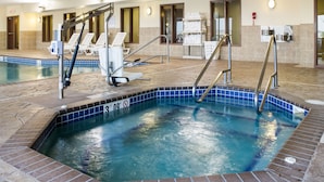 Ein Hallenbad mit Schild für klares Wasser, einem Rettungsschwimmerstuhl und einem Handtuchhalter.