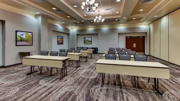 A conference room with long tables, chairs, and a chandelier.