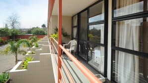 A balcony with a view of a garden and a building. - Ascot Epsom Motel (Auckland)
