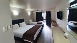 A hotel room with two beds, a desk, a chair, a TV, and a window with curtains. - Ascot Epsom Motel (Auckland)