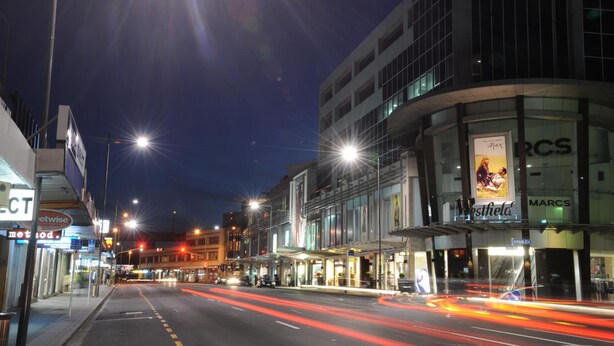 A nighttime street view with a building featuring a 'Marcs' sign and a 'Westfield' sign. - Ascot Epsom Motel (Auckland)