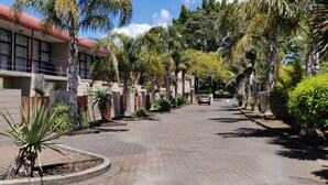 A residential street lined with palm trees and a building with balconies. - Ascot Epsom Motel (Auckland)