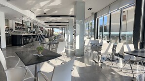 A modern restaurant with a bar area, large windows, and a clean, contemporary interior. - Nautic Hotel & Spa (Palma de Mallorca)