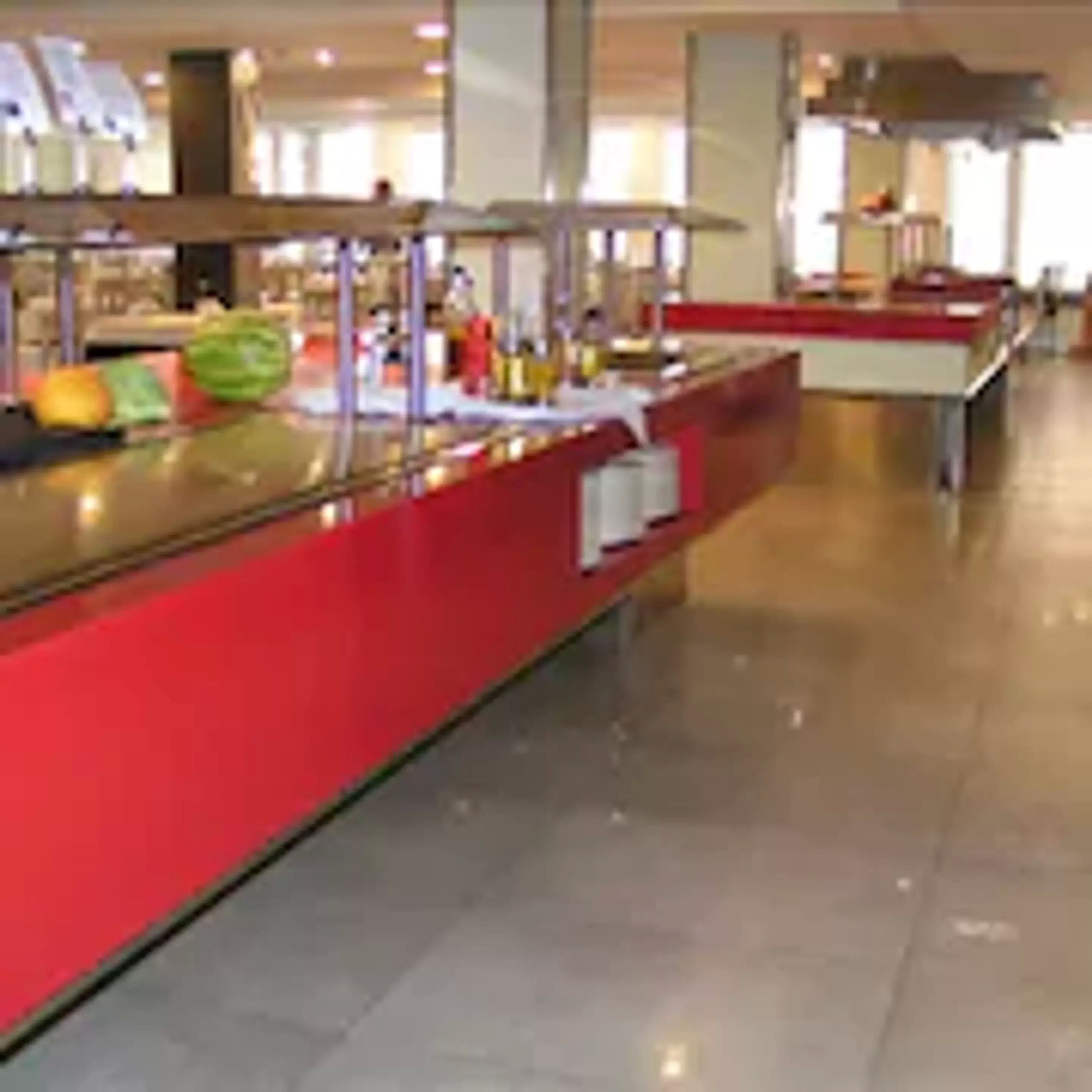 Zona de bufé con un mostrador rojo y diferentes platillos.