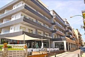 Ett hotell med flera våningar, utomhusservering och en restaurang.