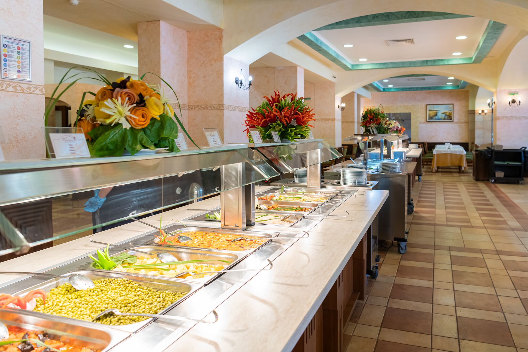 A buffet area with various food stations, a reception desk, and a seating area.