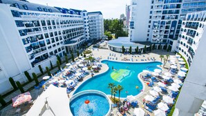 Hotel com várias varandas, área de piscina central com espreguiçadeiras e uma piscina menor separada.