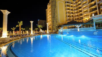 Una piscina techada, una piscina al aire libre de temporada, sombrillas