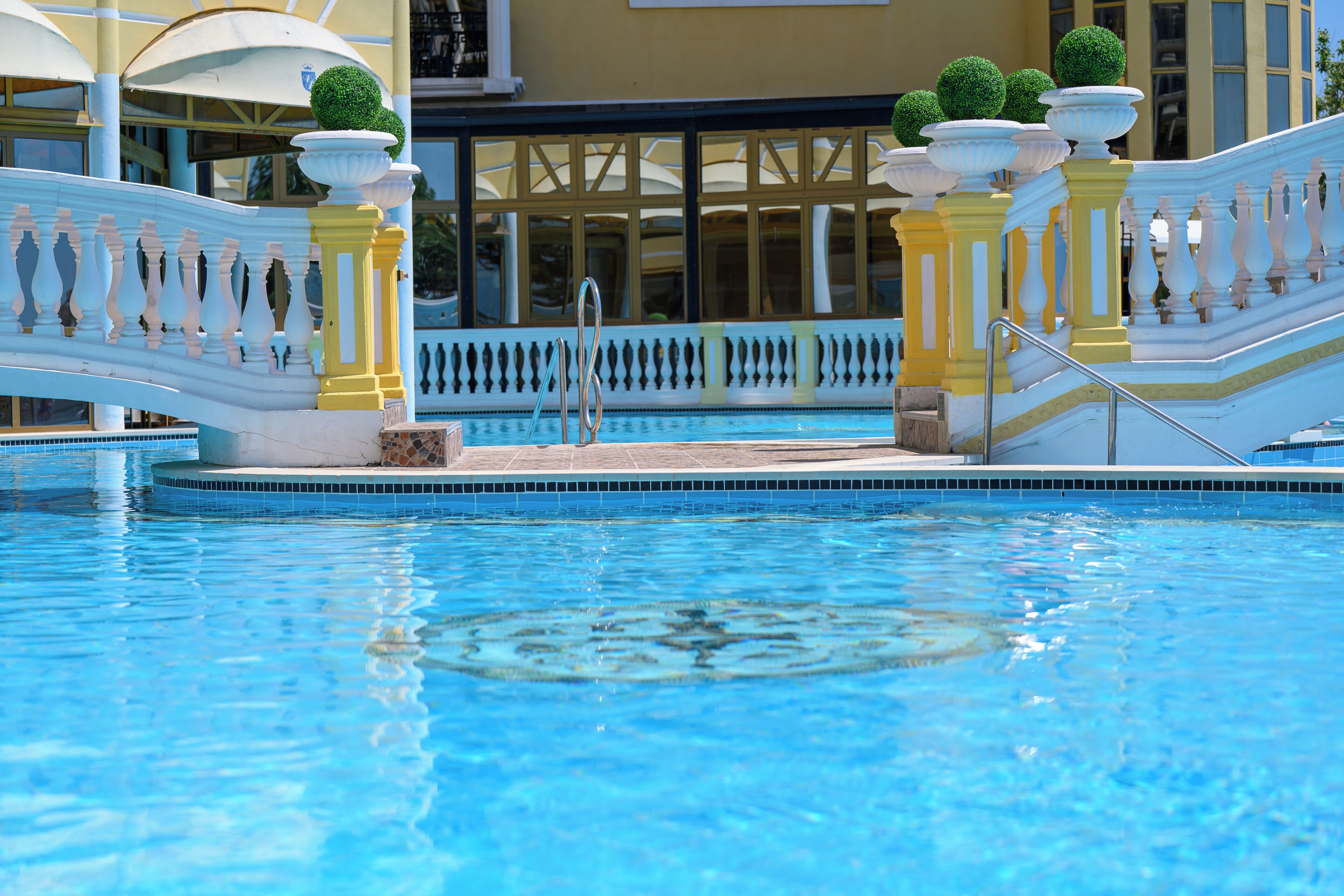 Una piscina techada, una piscina al aire libre de temporada, sombrillas