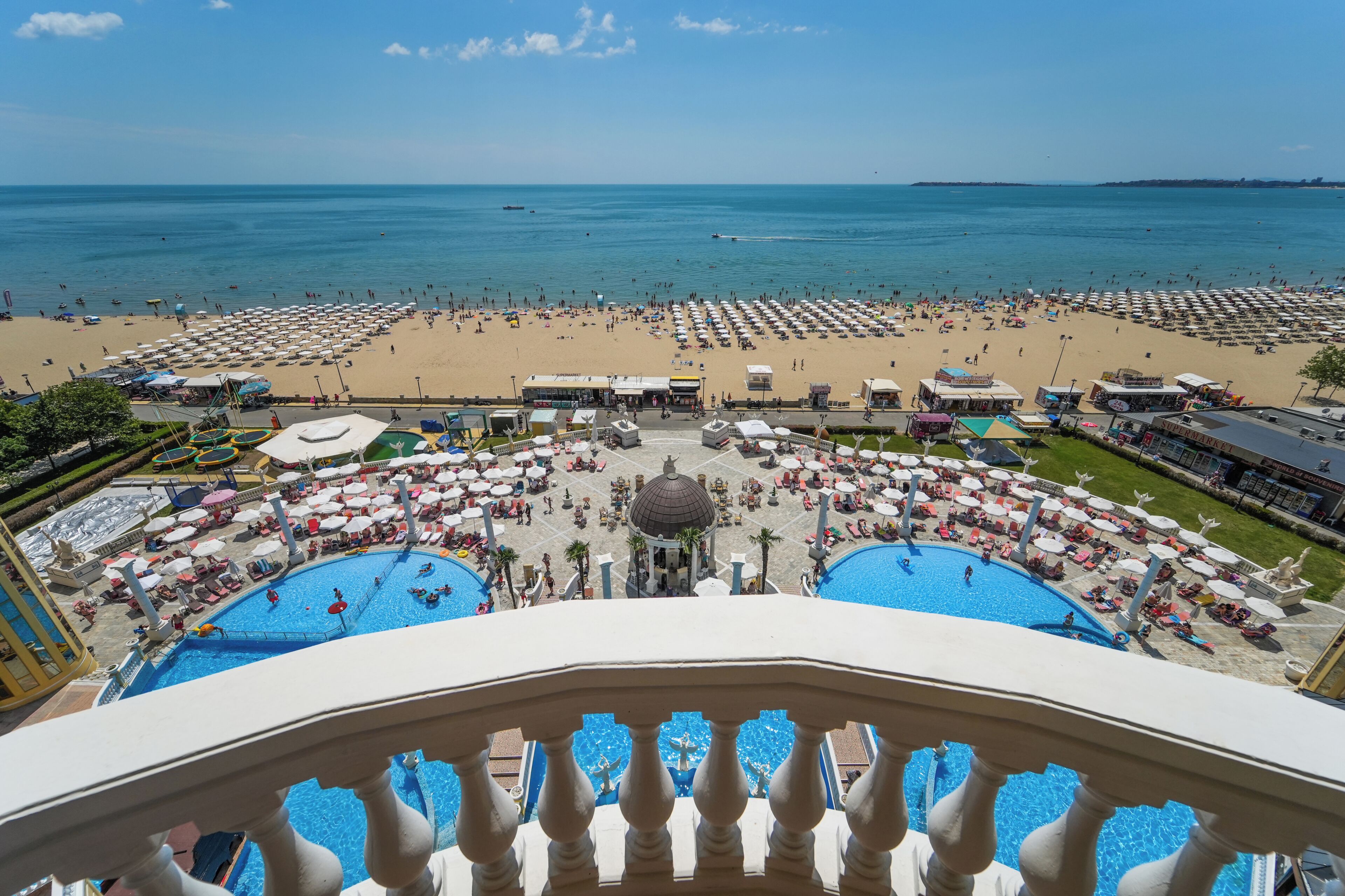 A resort with multiple swimming pools, beach areas, and a view of the sea.