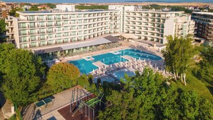 A multi-story hotel with a central swimming pool surrounded by lounge chairs and umbrellas. - Festa Panorama Hotel (Nessebar)