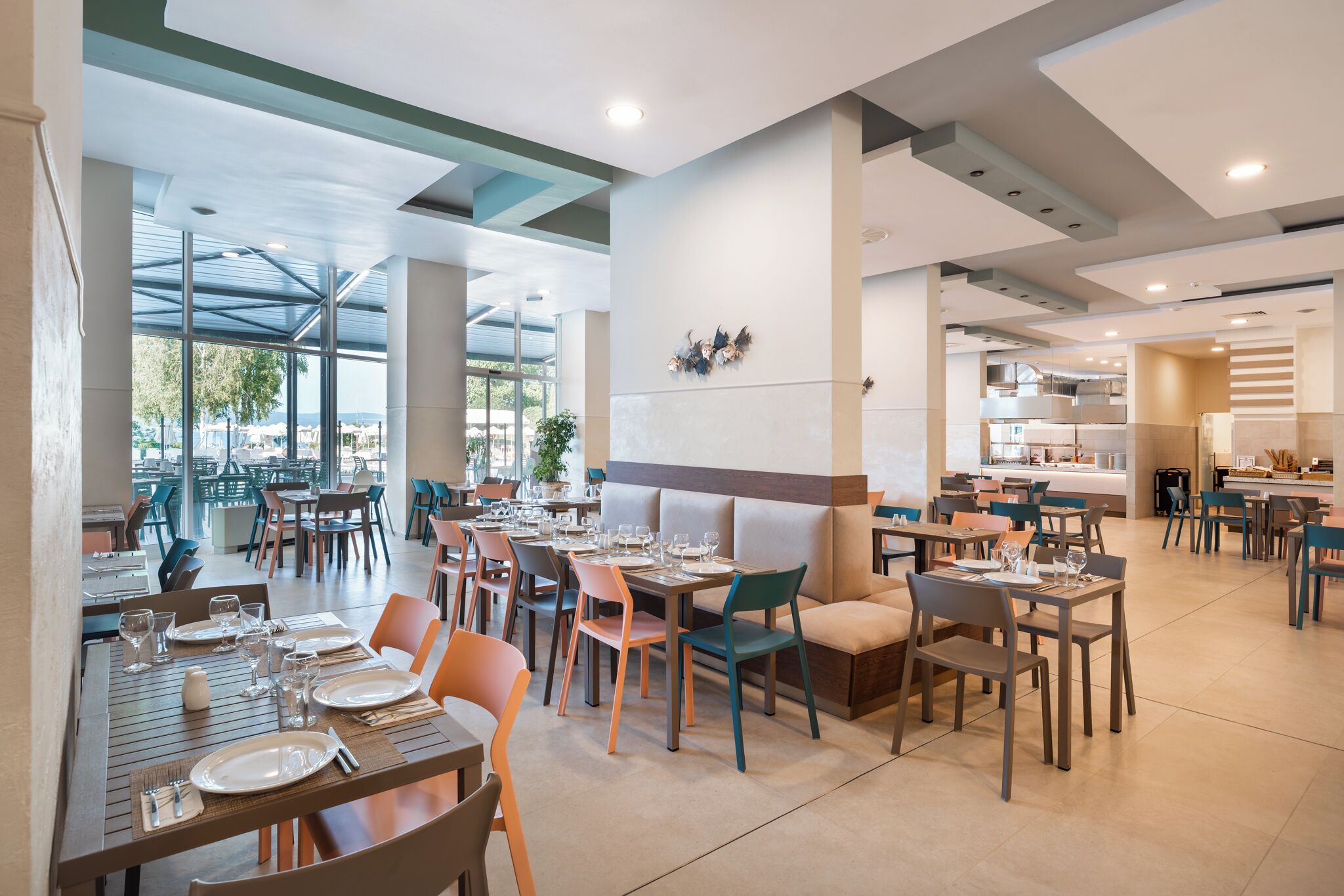 A modern restaurant with high ceilings, large windows, and a variety of seating options including tables and booths.