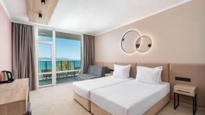 Quarto de hotel com uma cama grande, uma escrivaninha e vista para o exterior.