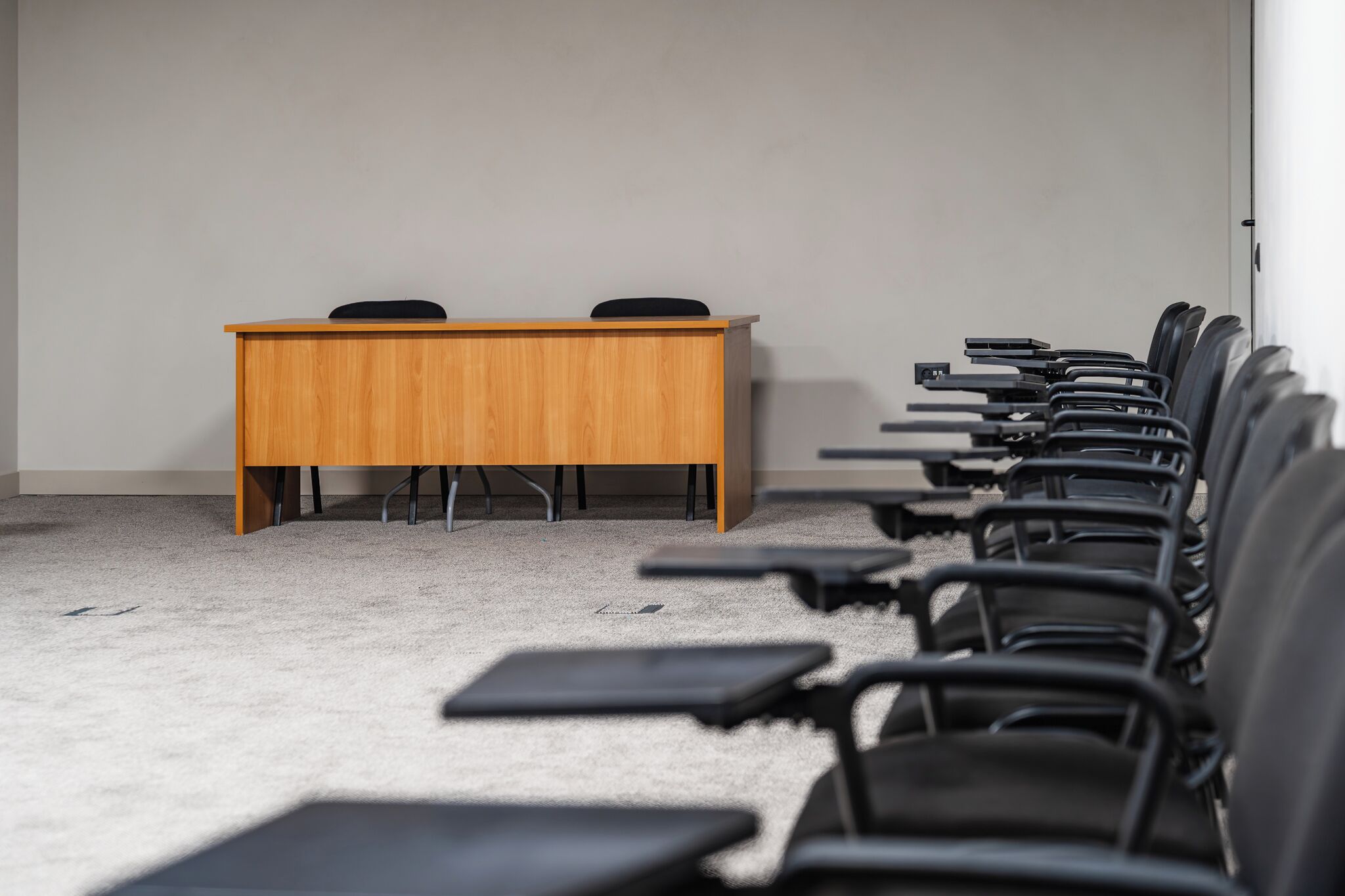 A conference room with a wooden table and chairs.