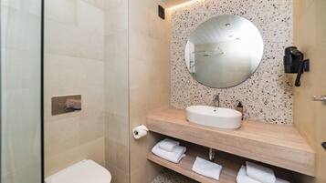 Une salle de bain moderne avec des toilettes, un lavabo et un miroir.