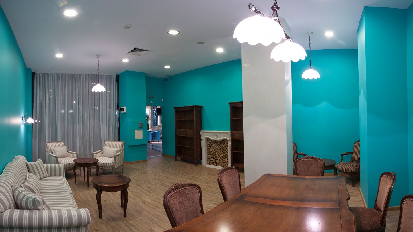 Un salón amplio con una gran mesa de comedor de madera, varias sillas, un sofá y una chimenea.