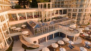 A multi-story hotel with a central courtyard, outdoor seating, and a pool area. - Azalia Hotel Balneo & SPA (Varna)