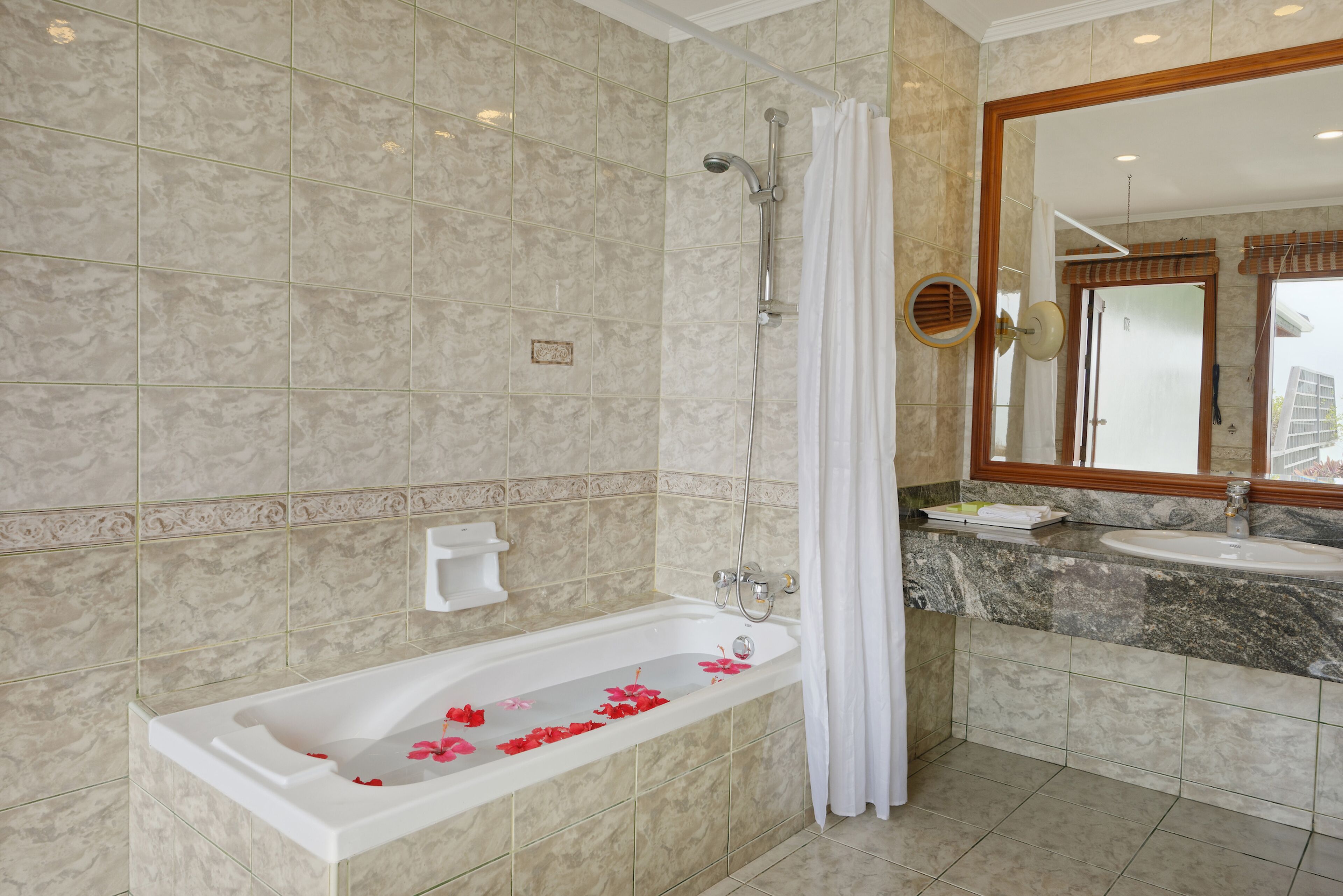 A bathroom with a bathtub, shower, and sink.