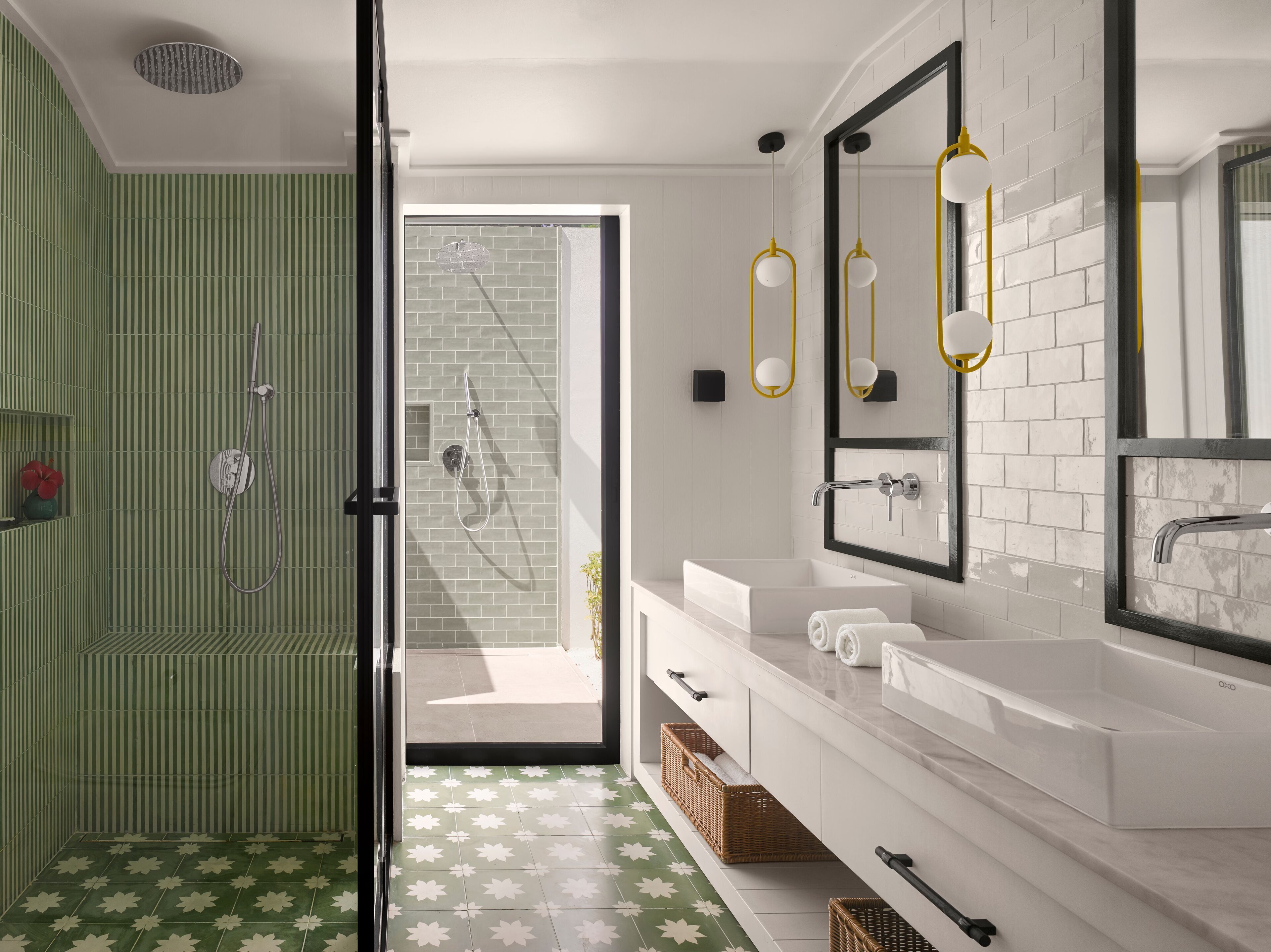 Un baño moderno con ducha, un espejo grande y un tocador blanco.