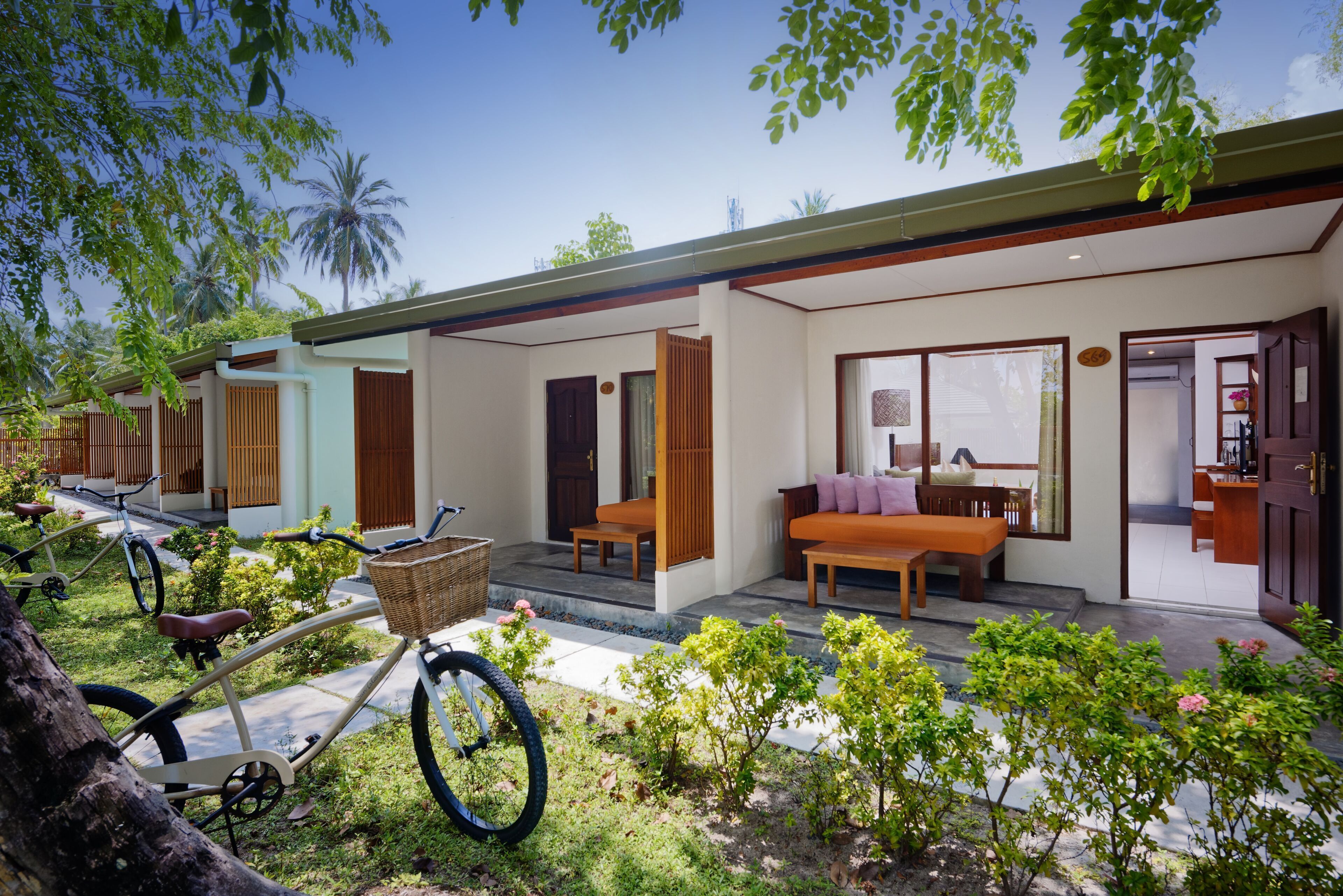 A modern house with a covered porch, a bicycle, and a small garden.