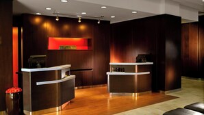 A reception area with two counters, wooden paneling, and a red accent wall. - Courtyard by Marriott Nashville Goodlettsville (Goodlettsville)