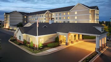 A hotel with a covered entrance, multiple floors, and a parking lot.