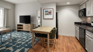A compact living space with a kitchenette, a dining area, and a television. - Homewood Suites by Hilton Minneapolis/St. Paul-New Brighton (New Brighton)